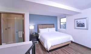 a hotel room with a bed and a bathroom at Candlewood Suites Baltimore - Inner Harbor, an IHG Hotel in Baltimore
