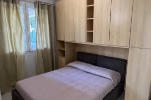 a small bedroom with a bed and wooden cabinets at Plumosus in Arma di Taggia
