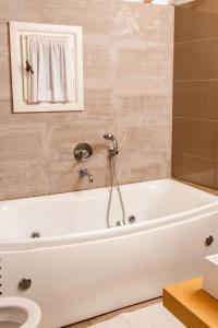 uma banheira branca na casa de banho com WC em The Dream em Castória
