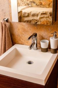 La salle de bains est pourvue d'un lavabo blanc et d'un miroir. dans l'établissement The Dream, à Kastoria