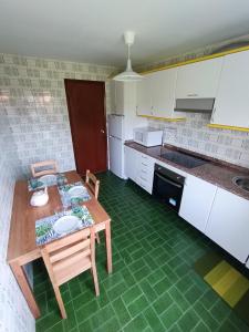 a kitchen with a wooden table and chairs in it at La Cruz del Sur - "ONS" in Sanxenxo