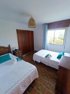 1 Schlafzimmer mit 2 Betten und einem Fenster in der Unterkunft La Cruz del Sur in Sanxenxo
