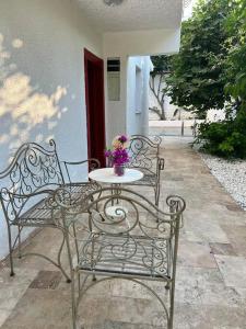 two chairs and a table with flowers on a patio at Doğa içinde havuzlu villa in Aydın