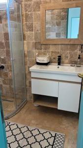 a bathroom with a shower and a sink and a mirror at Doğa içinde havuzlu villa in Aydın