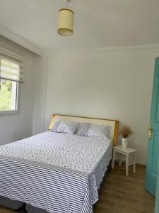 a white bedroom with a bed with a blue door at Doğa içinde havuzlu villa in Aydın