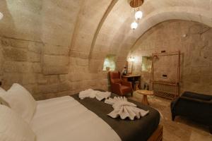 a bedroom with a large bed with towels on it at Göreme Escape Cave Suites in Goreme