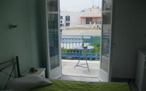 a bedroom with a door open to a balcony with a table at Very-Kokkos Pension 2 in Naxos Chora
