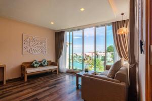 a living room with a couch and a large window at Vannee Golden Sands Beachfront Resort in Haad Rin