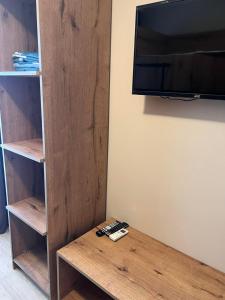 a room with a wooden book shelf and a tv at Villa Premium Shekvetili in Shekvetili