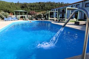 a swimming pool with a water fountain at Valonquinta - Agro Hotel & SPA in Vila Flor
