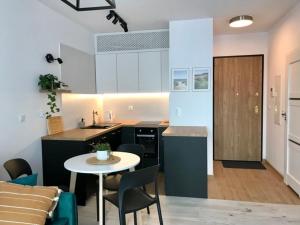 a kitchen and living room with a table and chairs at Studio Apartament Plac Unii Gdynia in Gdynia