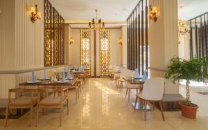 a dining room with tables and white chairs at Cloud City Hotel فندق مدينة السحاب in Al Baha