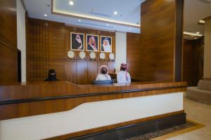 two people sitting at a counter in a courtroom at Cloud City Hotel فندق مدينة السحاب in Al Baha