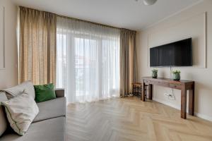 a living room with a couch and a large window at Willa Dattero Gdynia by Lion Apartments in Gdynia