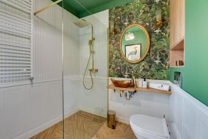 a bathroom with a shower and a toilet and a mirror at Willa Dattero Gdynia by Lion Apartments in Gdynia +15 photos