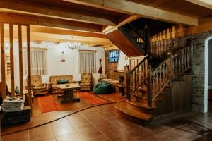 a large living room with a wooden staircase and a living room at DEMETER Guesthouse FOX Siclod in Şiclod