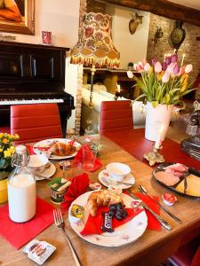 une table avec une assiette de nourriture et un piano dans l'établissement B&B Bourgeoisie***, à Frahan