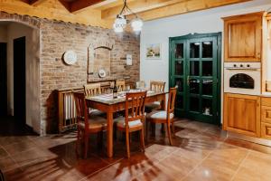 a kitchen with a wooden table and chairs at DEMETER Guesthouse FOX Siclod in Şiclod