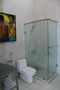 a bathroom with a shower with a toilet and a painting at Jade Waters 05 in Candi