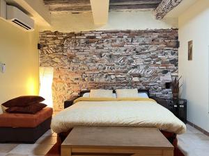 ein Schlafzimmer mit einer Steinmauer und einem Bett in der Unterkunft Le Pierrotin - superbe 2ch au coeur de Toulouse in Toulouse