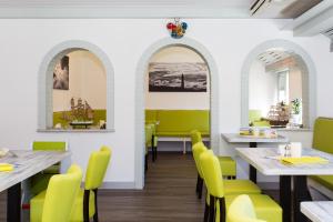 a dining room with tables and yellow chairs at Letj Briis in Norddorf