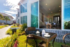 a house with a patio with a table and chairs at Vannee Golden Sands Beachfront Resort in Haad Rin