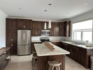 a kitchen with wooden cabinets and stainless steel appliances at Experience Coastal Charm-The Vista At Quidi Vidi! in St. John's