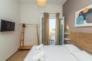 a bedroom with a large bed and a tv at Escape in Tinos in Tinos