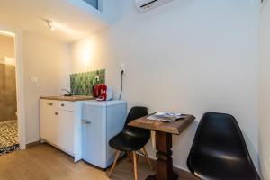 a small kitchen with a blue refrigerator and two black chairs at Escape in Tinos in Tinos