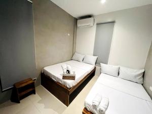 um pequeno quarto com duas camas e uma mesa em Barkada Room 1 near Clark (Casa Isabela) em Mabalacat