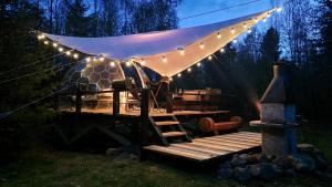 a tent with lights and a picnic table in the grass at Glamping Štôla- Perzeid in Štôla