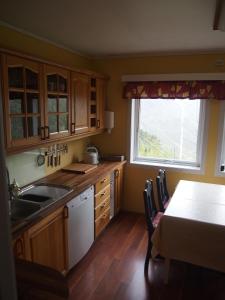 a kitchen with wooden cabinets and a table and a window at Lunheim in Geiranger in Geiranger +37 photos