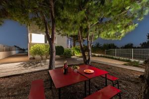 una mesa roja y dos sillas bajo un árbol en Sunshine Villa by Fidalsa en Los Montesinos