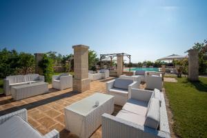 patio z białymi meblami i basenem w obiekcie TERRA TERRA - Masseria Minunni w mieście Conversano