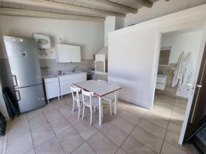 a small kitchen with a table and a refrigerator at Accogliente villa con piscina in Caltagirone