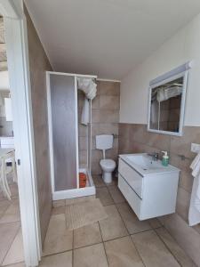 a white bathroom with a toilet and a sink at Accogliente villa con piscina in Caltagirone