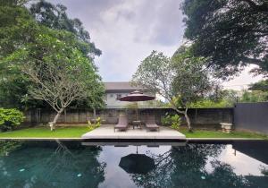 - une terrasse avec un parasol et des chaises à côté de la piscine dans l'établissement Bungalow with Pool Karaoke PJ 12, à Petaling Jaya