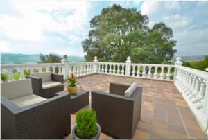 a balcony with couches and a white railing at Apartamentos Nel I in Santillana del Mar