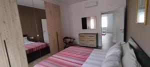 INTERNO NOVE - appartamento a Corsico في كورسيكو: غرفة نوم بسريرين وخزانة فيها