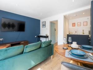 a living room with a green couch and a table at Pass the Keys Lovely 1 bed apartment close to city centre in Bath