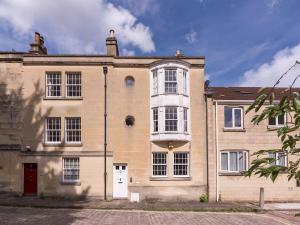 a large brick building with a red door at Pass the Keys Lovely 1 bed apartment close to city centre in Bath
