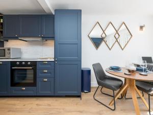 a kitchen with navy blue cabinets and a table at Pass the Keys Lovely 1 bed apartment close to city centre in Bath
