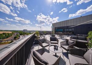 un balcone con sedie e tavoli su un edificio di Dorint Hotel München/Garching a Garching bei München