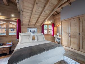 a bedroom with a large bed and wooden walls at Chalet cosy au centre de Courchevel Le Praz avec sauna, terrasse et parking - FR-1-568-15 in Courchevel