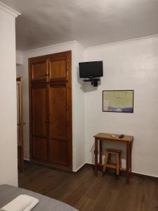 a room with a door and a table and a television at El Cruce Hornos in Hornos