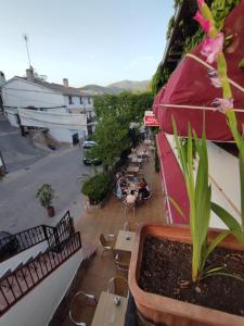 uma varanda com mesas e cadeiras e um guarda-sol em El Cruce Hornos em Hornos