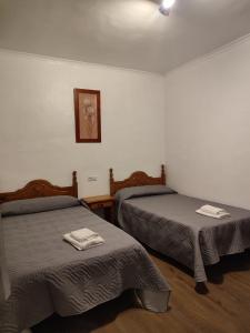 Habitación con 2 camas y una foto en la pared. en El Cruce Hornos, en Hornos