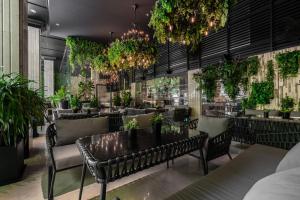 a restaurant with tables and chairs and potted plants at Paragon Saigon Hotel in Ho Chi Minh City