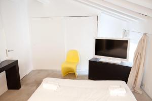 a living room with a yellow chair and a television at Casa Valentina in Mantova