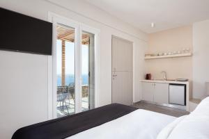 1 dormitorio con cama y vistas al océano en Kythea Suites Kythnos, en Kithnos